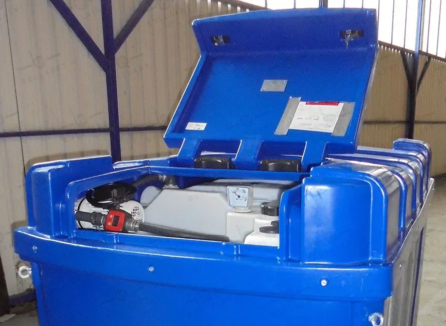 Vue de l'intérieur d'une cuve AdBlue avec le couvercle ouvert, montrant les équipements inclus tels que la pompe 220V, le flexible EPDM, le pistolet manuel, et la jauge mécanique.